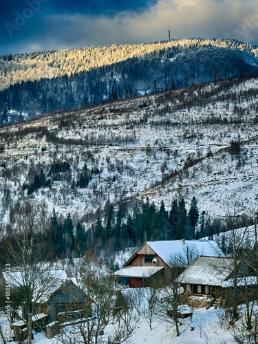 Mystical snowy Carpathian peaks under cloudy skies in the sunny weather