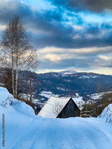 Mystical snowy Carpathian peaks under cloudy skies in the sunny weather