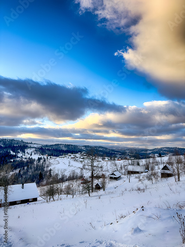 Mystical snowy Carpathian peaks under cloudy skies in the sunny weather