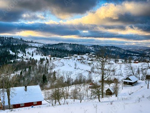 Mystical snowy Carpathian peaks under cloudy skies in the sunny weather