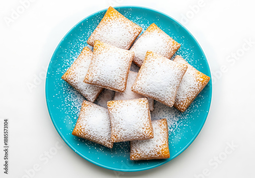 Delicious beignets dusted with powdered sugar on a blue plate