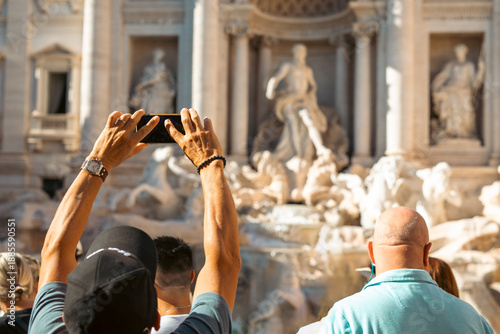 Tableau sur toile Tourists capturing the grandeur of an iconic Roman fountain on a sunny day