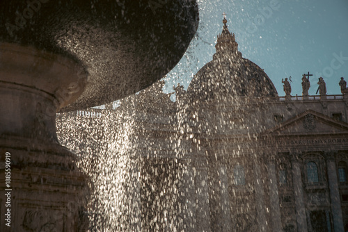 Fountain water cascading before an iconic dome and statues, captured in soft afternoon light.
