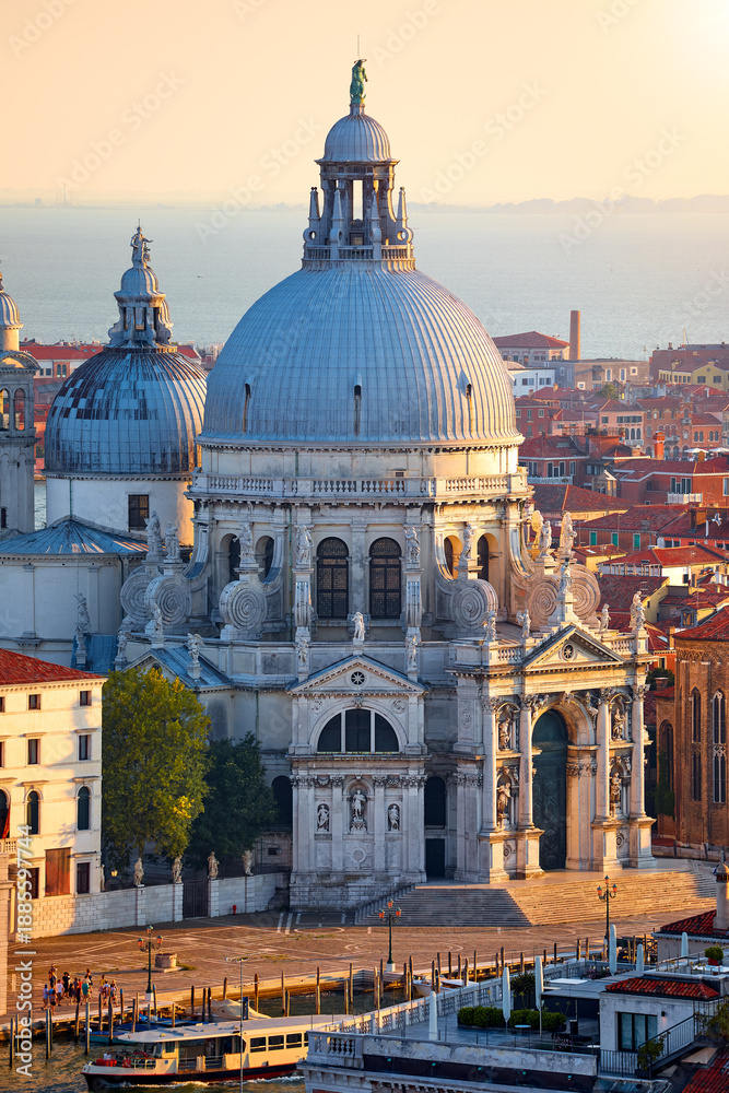 Fototapeta premium Venice, Italy. Cathedral of Santa Maria della Salute in Venice old town, Italy. Antique medieval building with dome at banks of Grand Canal. Water tram on Canal. Top view of famous landmark in Europe.