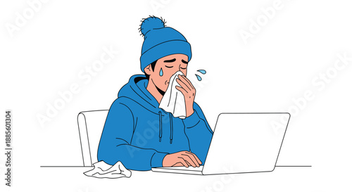 Person wearing a winter hat and hoodie blowing their nose with a tissue while working on a laptop, depicting illness at work.