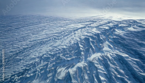Aerial view of icy landscape with snow-covered mountains and glaciers.