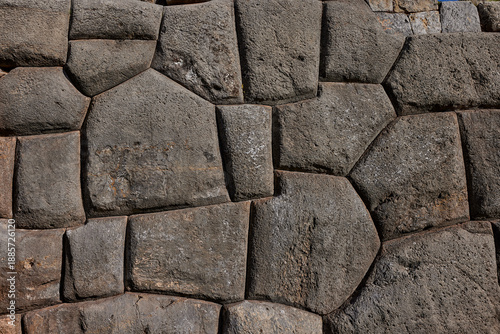 a high-detail close-up of the megalithic stone masonry at the fortress of Sacsayhuamán, located on the outskirts of Cusco. This site is a masterpiece of Inca engineering 