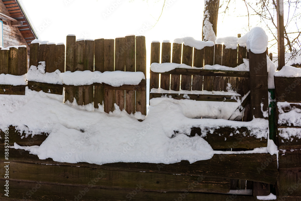 custom made wallpaper toronto digitalAn old wooden fence, heavily laden with pristine white snow, basks in soft winter sunlight. A quiet January morning scene, evoking tranquil rural charm