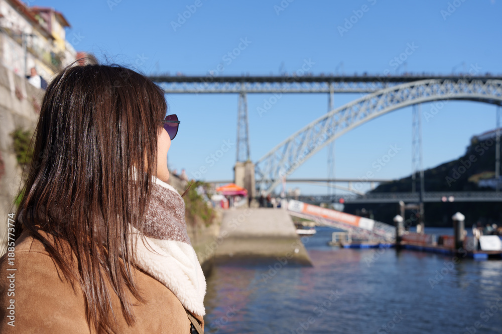 Fototapeta premium Woman admiring dom luís i bridge porto view