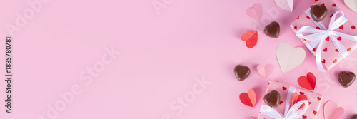 Cute pink background for Valentine Day. Valentines greeting card flat lay with gifts box with ribbons, chocolates and heart decor top view copy space