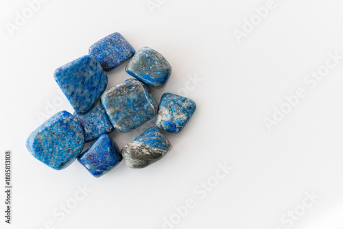 Fotografía Blue lapis lazuli stones grouped together, polished mineral pieces with natural colour variation and texture, studio lighting, white background, copy space for branding and packaging