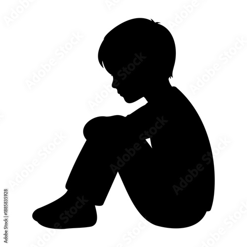Black silhouette of a lonely young boy sitting on the ground feeling sad