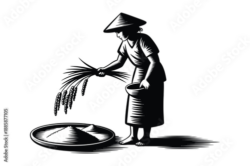 A traditional farmer in a conical hat working with freshly harvested rice stalks