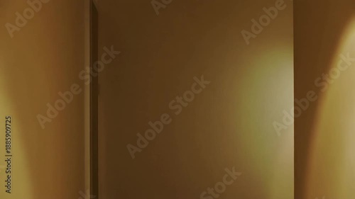 Warm light illuminates a minimalist, neutral-toned interior corner with soft shadows.