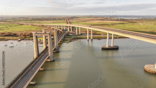 Wallpaper Mural Aerial view of Sheppey Crossing Bridge casting long shadows over the tranquil waters below, connecting the Isle of Sheppey to the mainland under a soft, golden light, Sittingbourne, United Kingdom. Torontodigital.ca