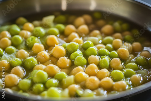 Chef preparing chickpeas and peas in a pan