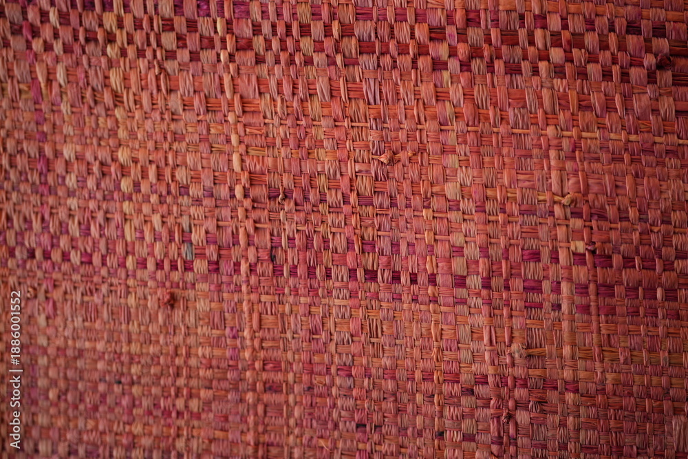 Fototapeta premium Red pink woven raffia straw texture background