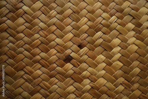 Natural raffia straw bag texture with a woven ornamental pattern. Close-up of handmade straw weaving in warm beige tones, ideal for fashion, eco design, summer accessories, backgrounds, and sustainabl