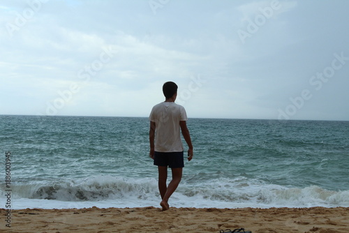 young man walking on the beach