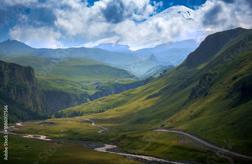 Expansive panoramic view of green mountain hills with dramatic cloudy sky.  N atural landscape captured in 7K high resolution on Sony A7 IV. Ideal for backgrounds or eco travel themes