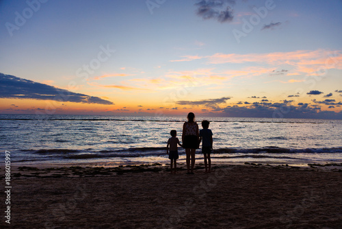 Woman and children contemplating the landscape at a beach in the Riviera Maya at sunrise