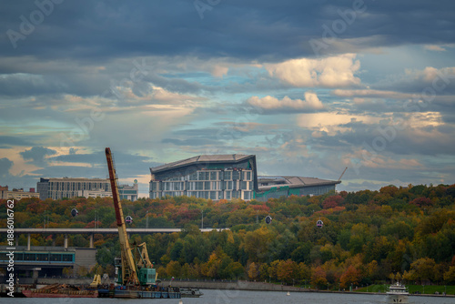 Moscow State University building with autumn forest and river view.Modern MSU building in Moscow above colorful autumn forest, with river and infrastructure in foreground