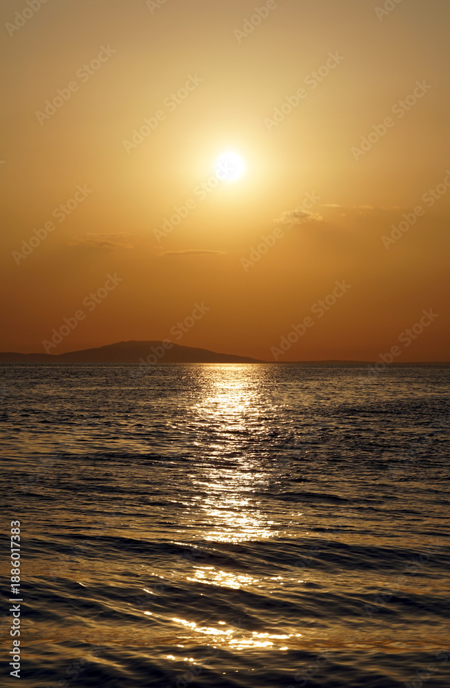 Fototapeta premium Minimal seascape with golden sunlight reflection on the seawaves