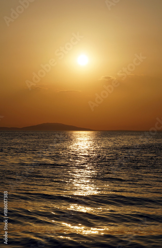 Minimal seascape with golden sunlight reflection on the seawaves