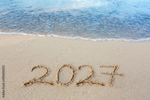 2027 hand written in sand on a beautiful beach