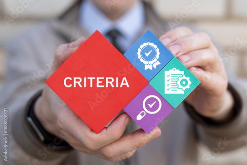 Business person holding colored styrofoam blocks sees the text CRITERIA. Criteria Controlling Follow Guidelines Conduct Concept. Criteria evaluation. Goal setting and achievement strategy.