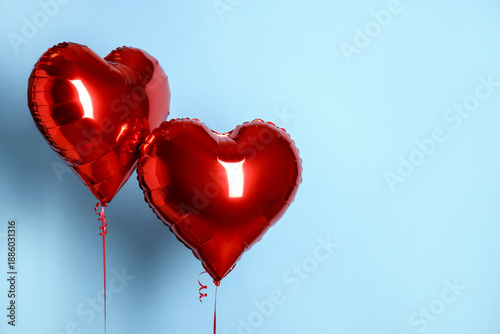 Tableau sur toile Heart-shaped red balloons on light blue background, space for text