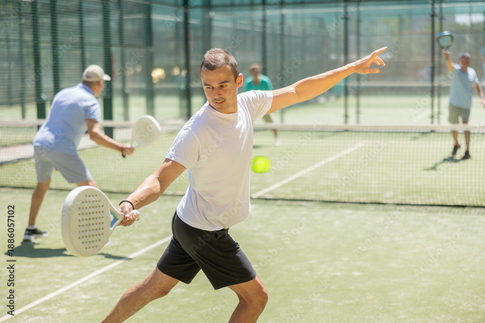 Obraz premium Active man with enthusiasm playing padel on the tennis court