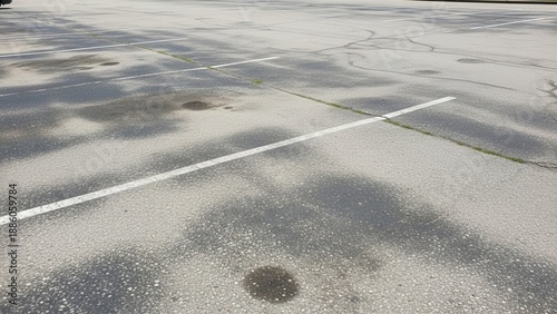 Asphalt Parking Lot With Water Stains and Faded White Lines
