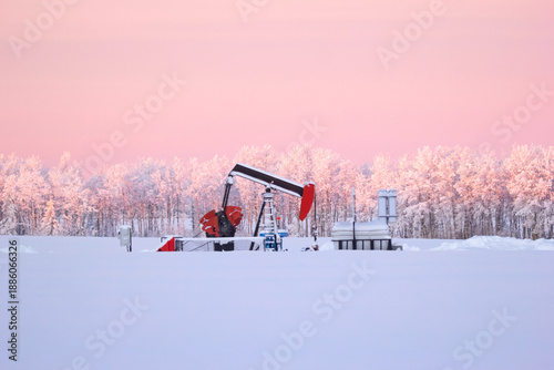 Obraz na plátně Snow Covered Oil Pumpjack at Winter Sunrise