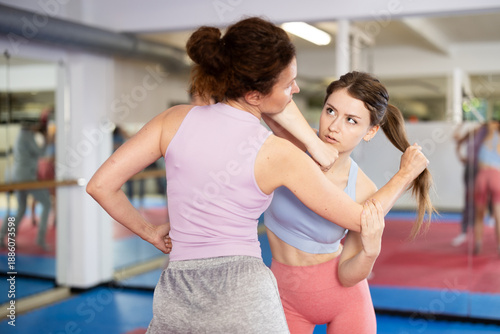 Canvas-taulu Purposeful female pupil clash with training manager during self-defense lesson,