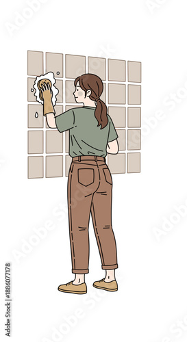 Woman cleaning tiles with a sponge while standing in a modern kitchen  