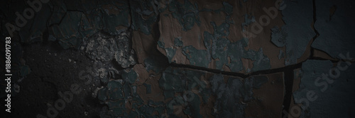 Dark wide panoramic background. Peeling paint on a concrete wall. Dark grunge texture of old cracked flaking paint. Weathered rough painted surface. Patterns of cracks. Darkness background for design.