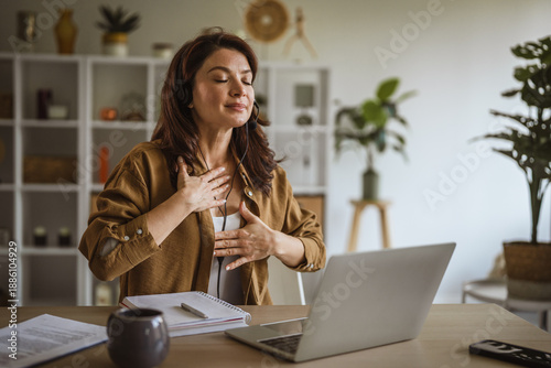 Quadro su tela Woman wearing headset meditating during mindful deep breathing exercise