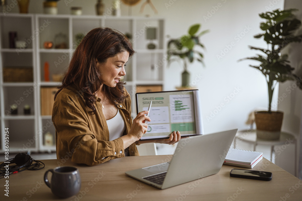 Fototapeta premium Woman presenting sales statistics online during a video call