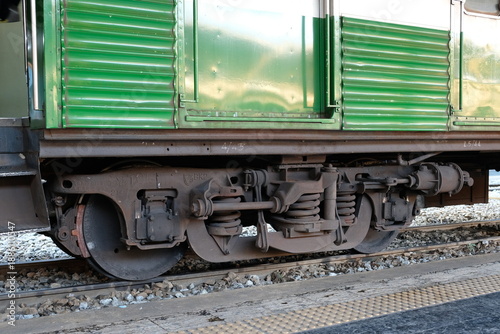 Canvastavla Close-up view of a green train's undercarriage and wheel assembly on tracks