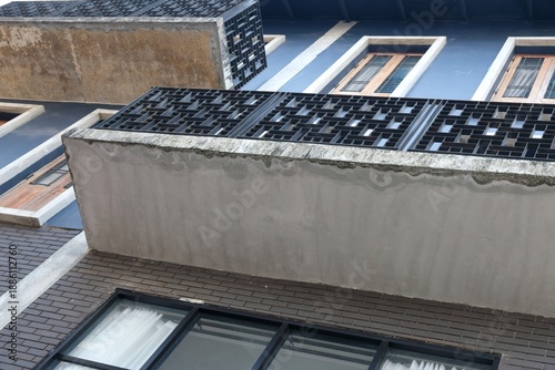 Foto Modern building facade with geometric balconies and windows, viewed from below