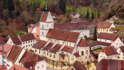 Aerial: Saint-Ursanne collegiate church during the day in Clos du Doubs, canton of Jura, Switzerland, orbit drone shot