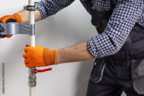 Technician plumber using a duct tape  to repair a water pipe. plumbing leak with duct tape.