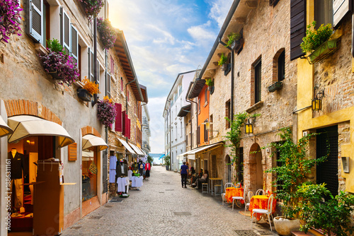 Fotografía A narrow cobblestone pedestrian street leading with views of Lake Garda in the historic medieval town of Sirmione, Italy