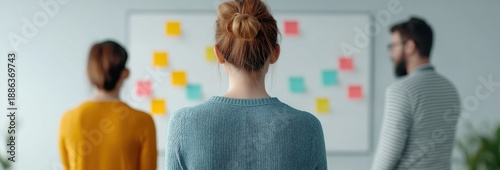 Group of young professionals collaborating on a project, analyzing data, and developing new strategies using colorful sticky notes