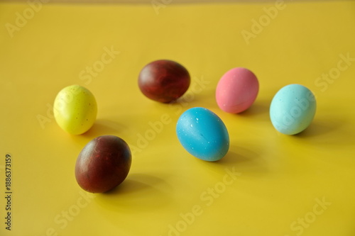 Colorful Easter eggs against yellow background