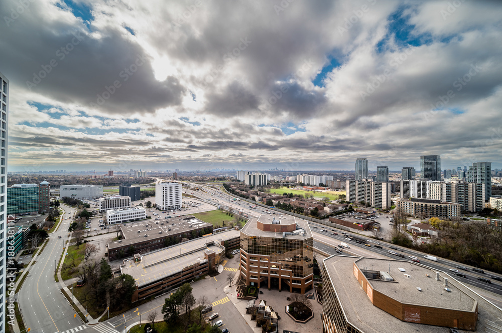 Obraz premium Toronto cityscape showing highway 427, various office buildings, residential high rises, and urban infrastructure under a cloudy sky covering a large metropolitan area