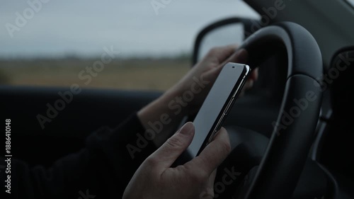 Irresponsible female driver using mobile phone while driving through countryside landscape. 4K.