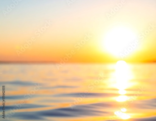 Soft, dreamy seascape. Bright sun reflected on rippling water and a hazy orange sky above the horizon