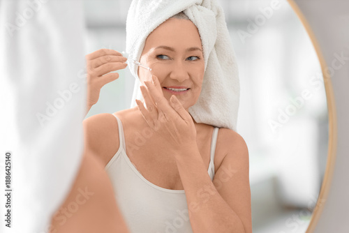 Mature woman applying colla...